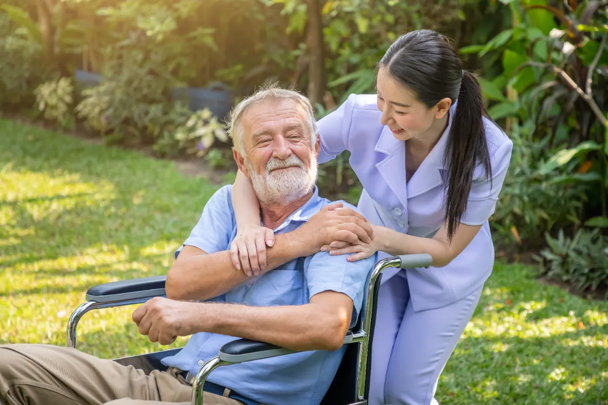 happy-nurse-holding-elderly-man-hand-wheelchair-garden-nursing-home (2)